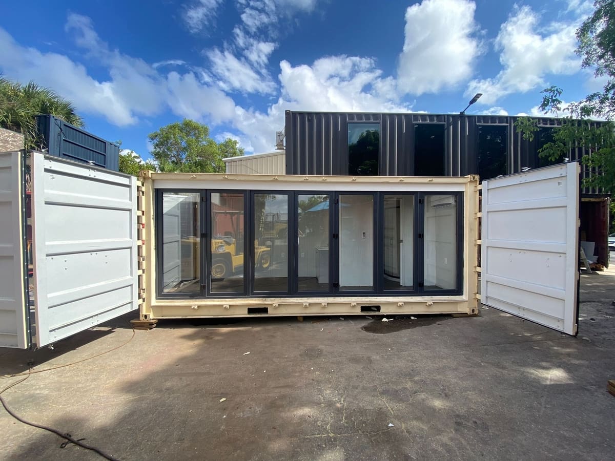 Shipping container with folding glass door