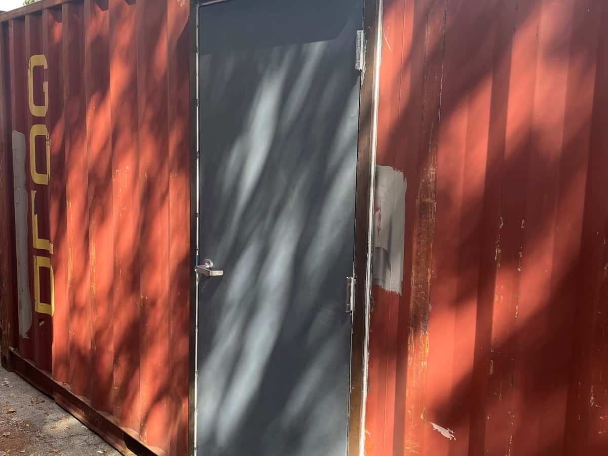 Red shipping container with a man door